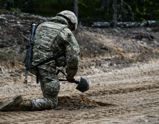 Finland destroyed a million landmines. Why does it want them back? A soldier kneels on a sandy forest track, burying a mine with a small shovel