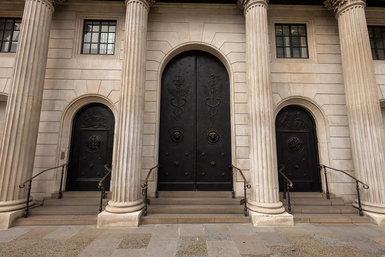 Heavy dark doors set between massive stone columns at the entrance of the Bank of England